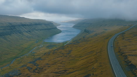 Viaje-Panorámico-Por-Carretera:-Vistas-Aéreas-Del-Automóvil-Seguidas-Por-Un-Dron-Que-Captura-El-Impresionante-Paisaje-De-Las-Islas-Feroe