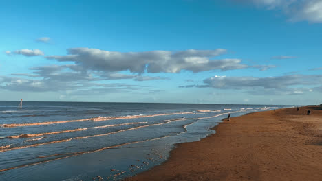 Warm coastal sunset scene with people walking through the image