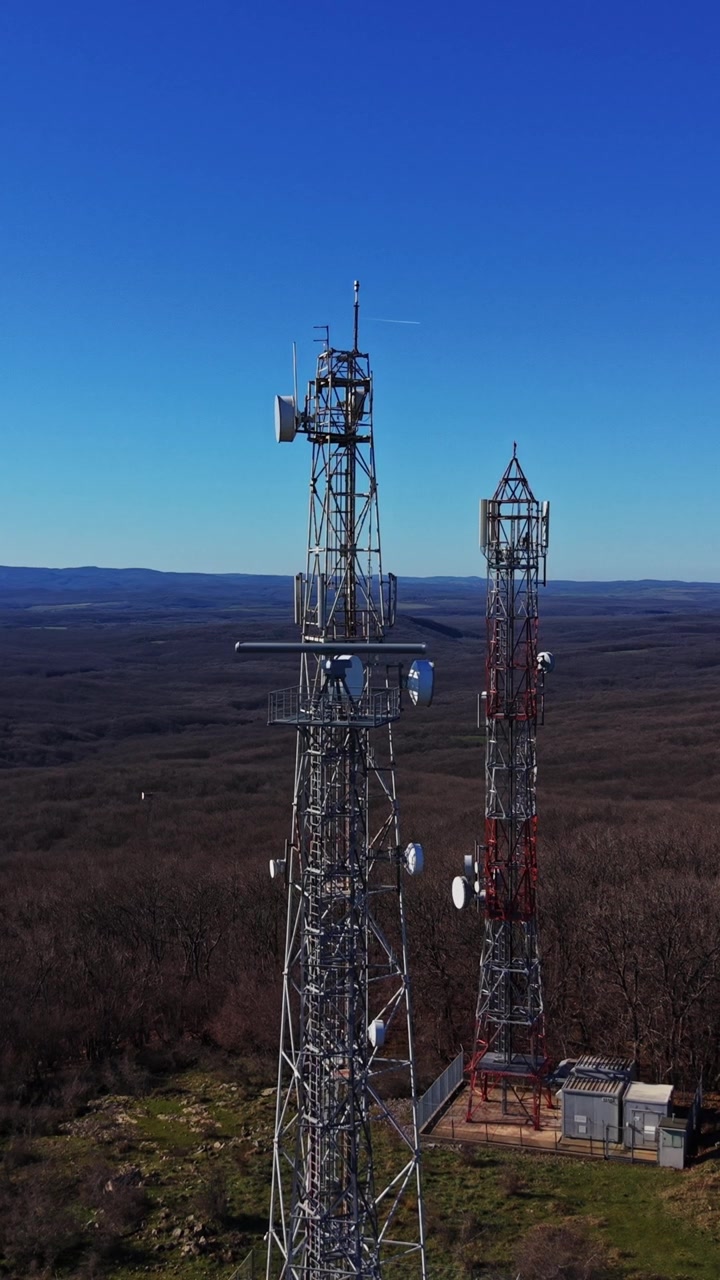 Torri di comunicazione si ergono alte nel paesaggio remoto sotto un cielo limpido