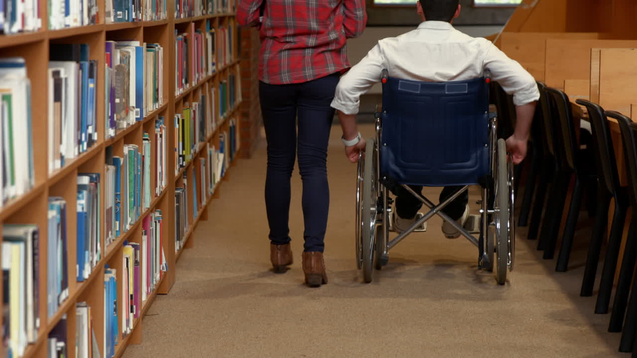 Disabled student and friend in the library