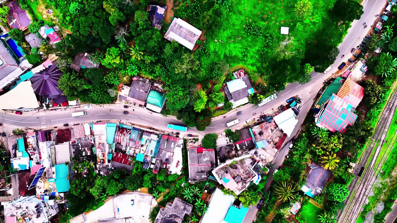 A vivid aerial view of Sri Lanka’s Buddhist Asapuwa Temple, nestled among small village houses, winding roads, tropical greenery, and surrounding lush landscape.