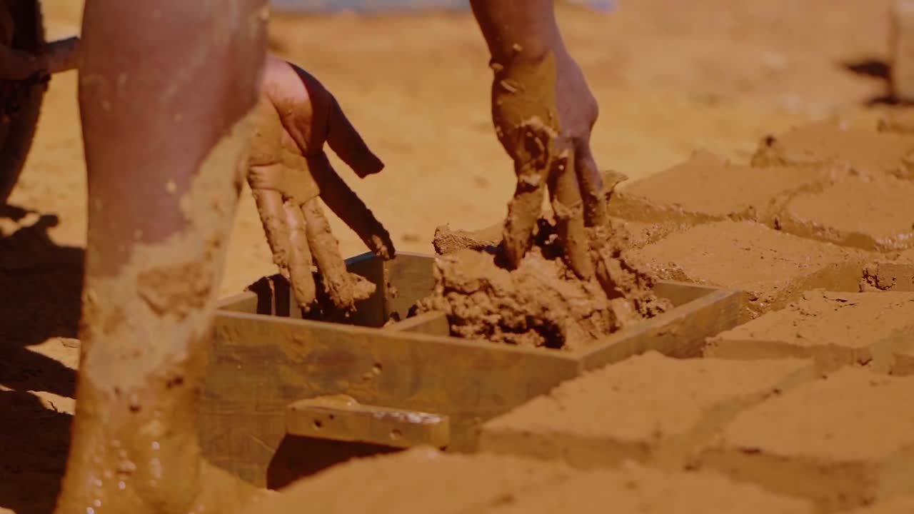Construction worker making adobe bricks using traditional methods in Chapada dos Veadeiros, Brazil, promoting sustainable and culturally relevant building techniques