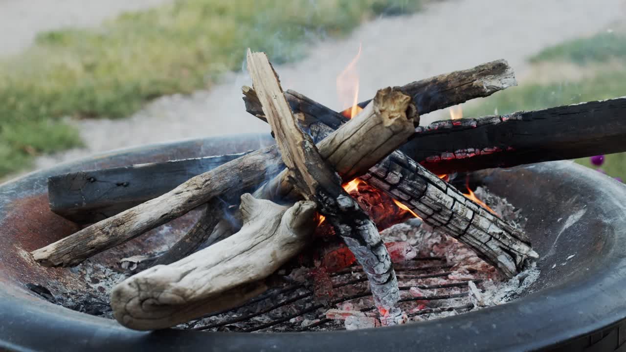 Handheld small fire building outdoors in the summer in slow motion