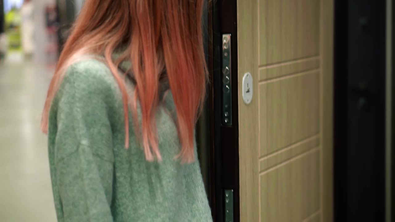 женщина выбирает двери в аппаратной, пробует ручки