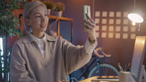 woman taking a selfie video call in a home office