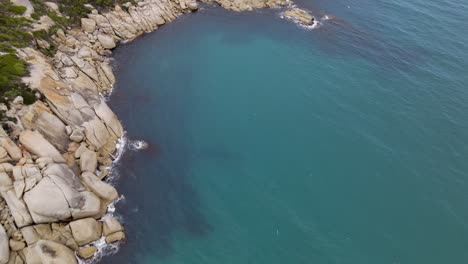 drone aerial rise up and pan up over beautiful blue water and white rocks on a sunny day in wilsons promontory