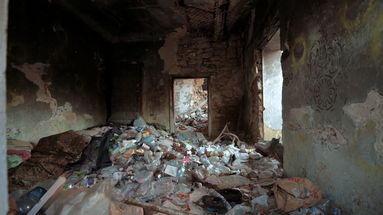 CHISINAU, MOLDOVA - 15 NOVEMBER, 2021: Lots of plastic garbage in an abandoned old house used by homeless people