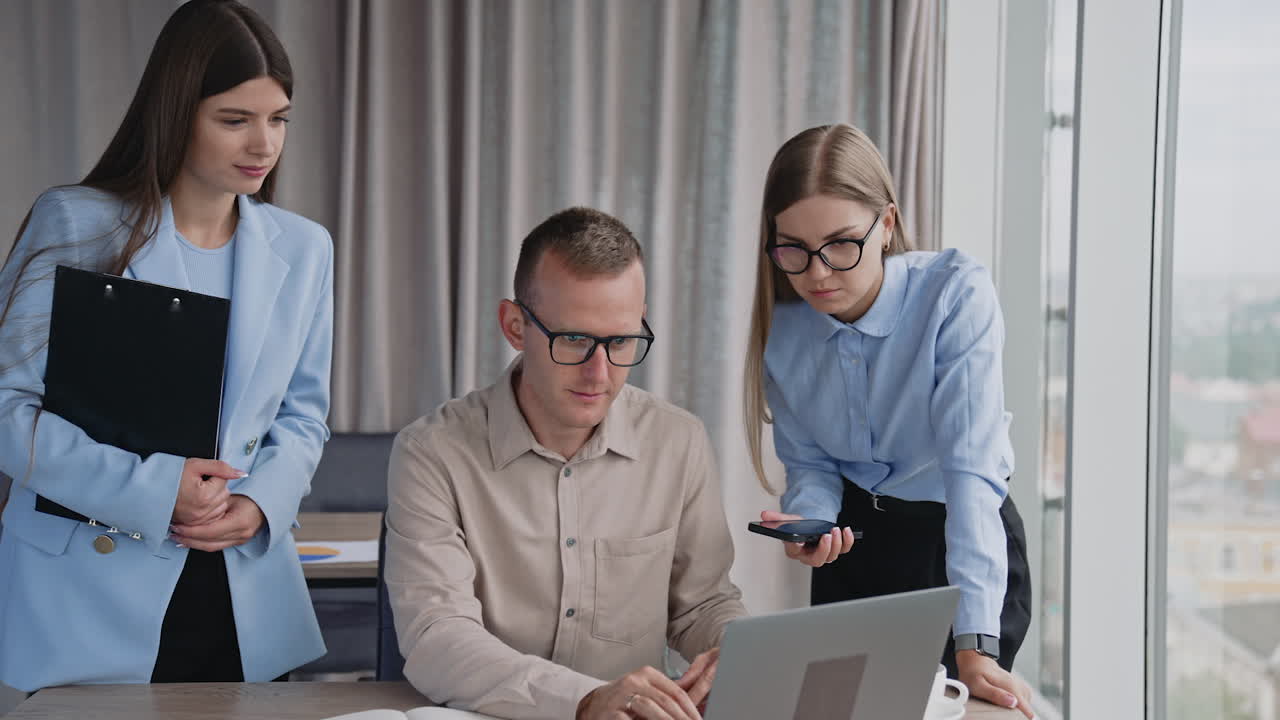 Three people looking at the screen of computer. Office colleagues cooperating to find the solution of job problem. Office background.