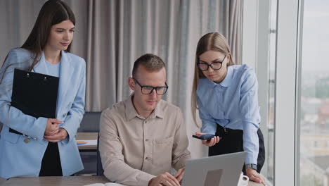 three people looking at the screen of computer. office colleagues cooperating to find the solution of job problem. office background.