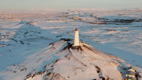 Reykjanesviti-Lighthouse-in-snow-covered-winter-season,-Iceland,-aerial