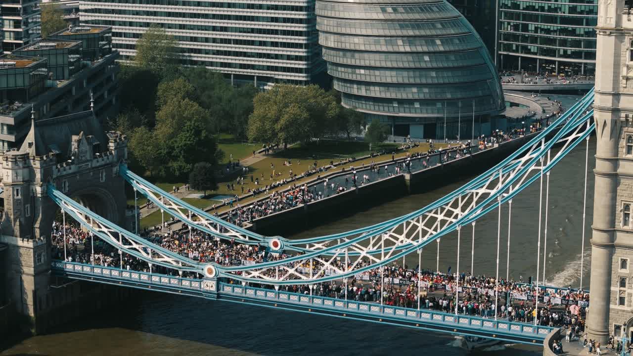 Crowds cheer as London Marathon runners cross Tower Bridge over the Thames