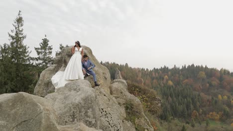 newlyweds stand on a high slope of the mountain. groom and bride