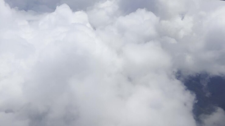 Footage of white clouds and sky in motion, captured from an airplane. Perfect for travel, aerial views, and nature projects, showcasing serene skies and dynamic movement above the landscape.