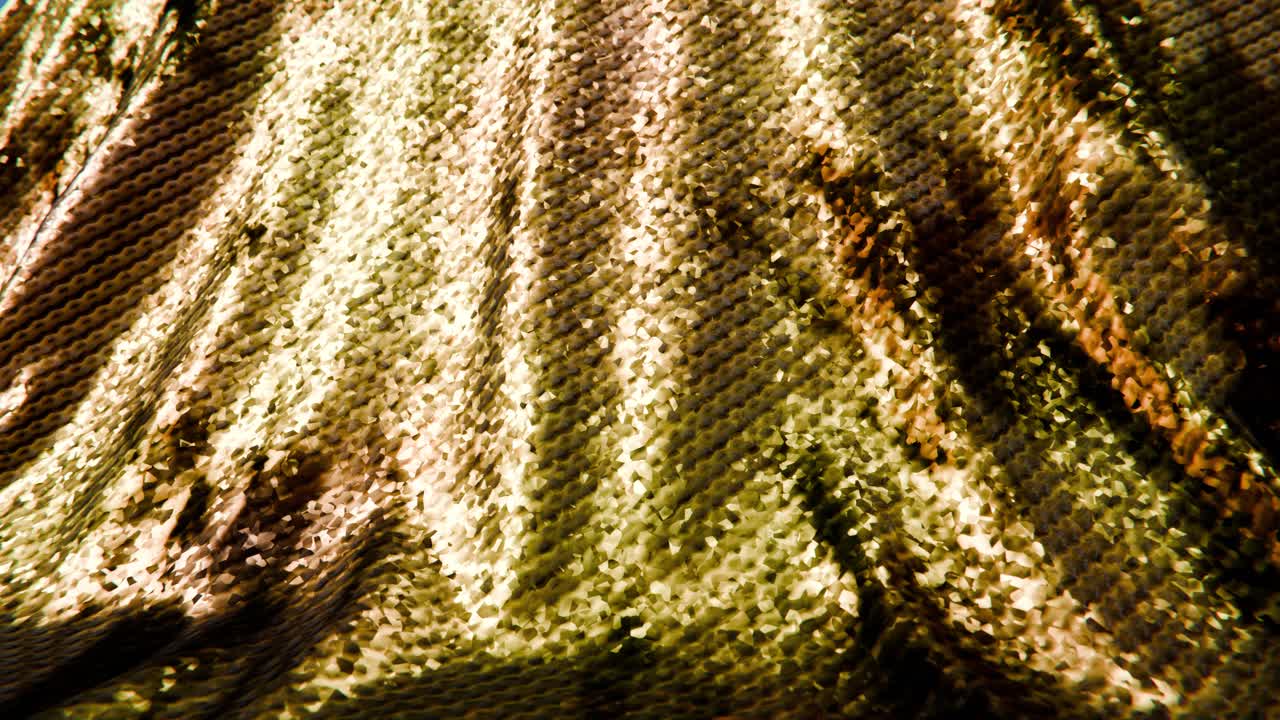 Nahaufnahme von goldenem Paillettenstoff mit schimmerndem Licht
