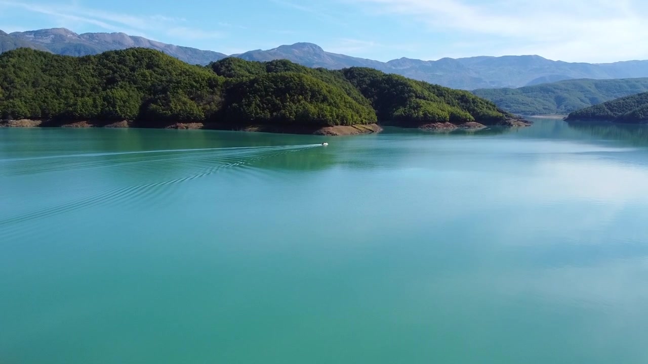Vista aerea di un motoscafo che naviga attraverso il lago blu del bacino di Bovilla in Albania