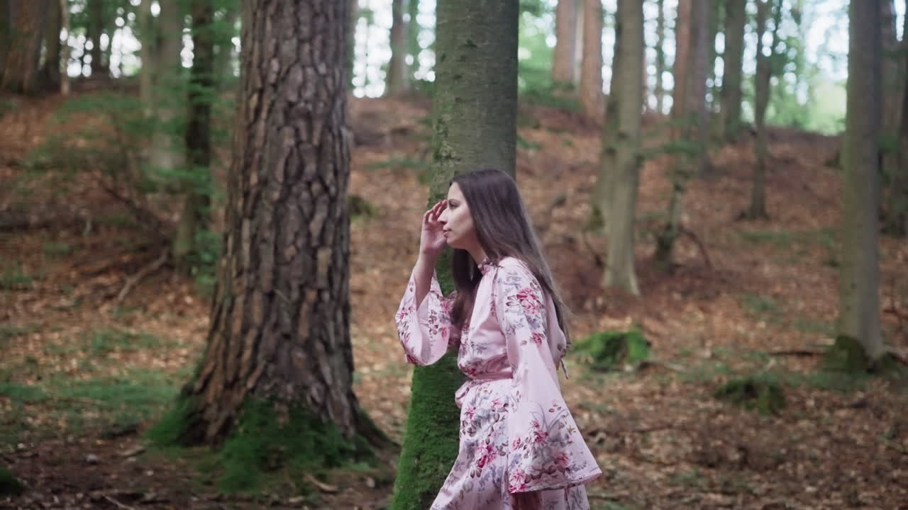 Una ragazza europea in abito floreale che cammina nella foresta di montagna.