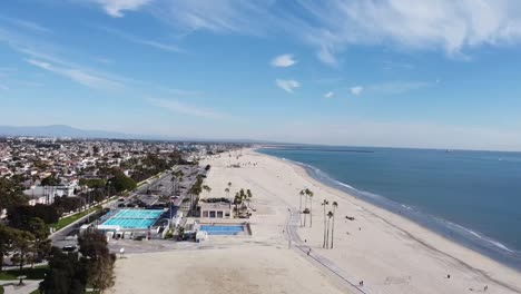 drone shot over beach and a swimming pool by a bike path