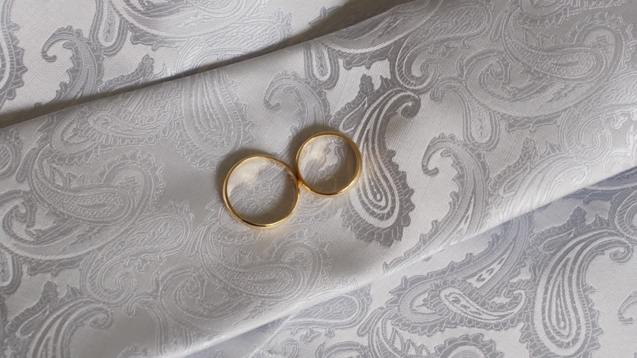 Due anelli d'oro su un elegante tessuto cachemire bianco, a simboleggiare l'amore e l'unione