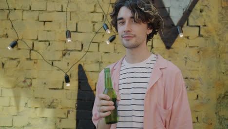 man holding a beer bottle outside
