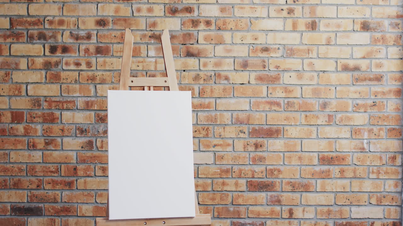 Video of white canvas sign on wooden easel with copy space on brick wall background
