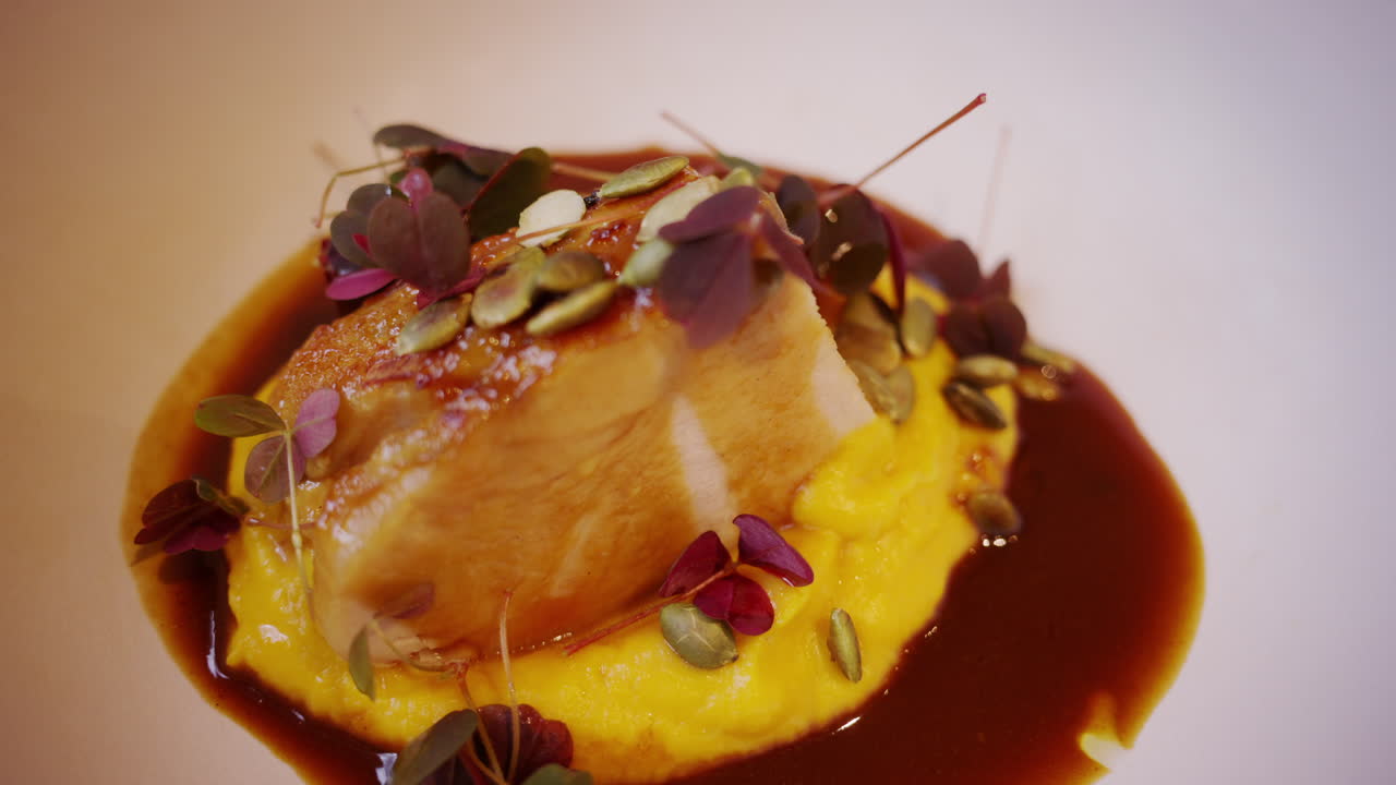 Hidangan fine dining elegan dengan saus, microgreens, dan biji-bijian.