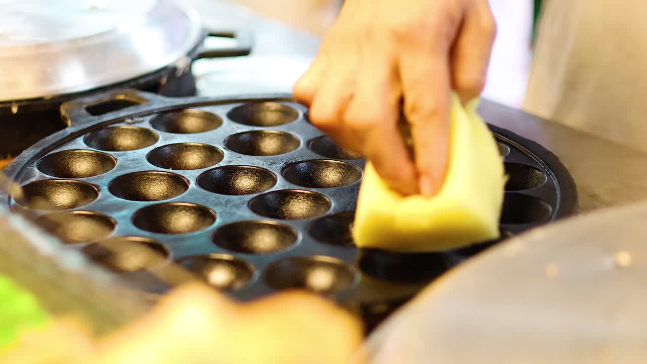 손으로 둥근 요리 모형에 반죽을 부어 넣는 것