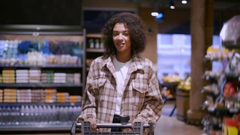 Una-Mujer-Bastante-Afroamericana-Camina-Por-El-Supermercado-Con-Un-Carrito