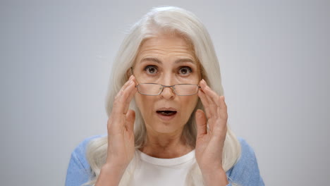 Stressed-senior-woman-looking-camera-indoors.-Mature-lady-fixing-glasses-inside.