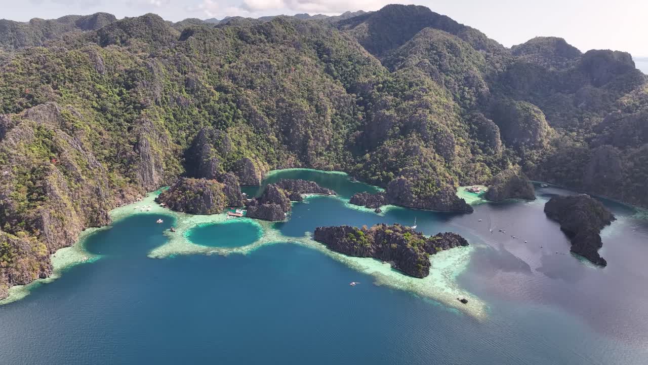High rise aerial of Coron Island coastal with cliffs and coral reefs, Twin Lagoon. Philippines.