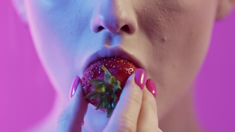 woman eating strawberry in neon lighting, close-up of face and mouth, romantic concept