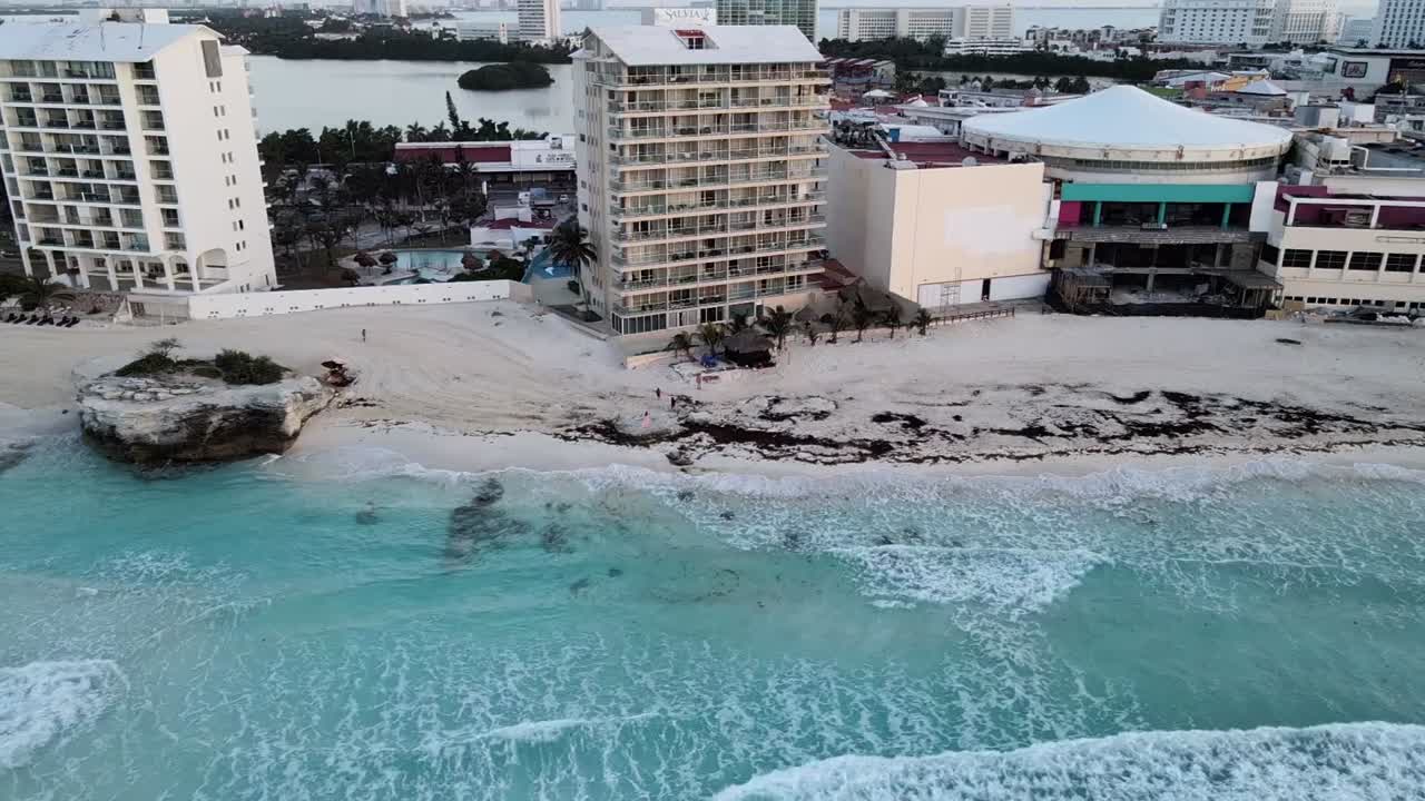 Aerial horizontal movement across the beaches of Cancun, Mexico's hotel zone during sunrise
