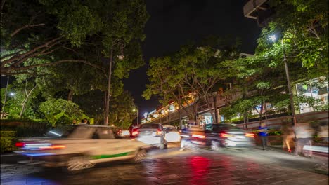 night traffic in mexico city, with busy streets and lights under large green trees, hyperlapse