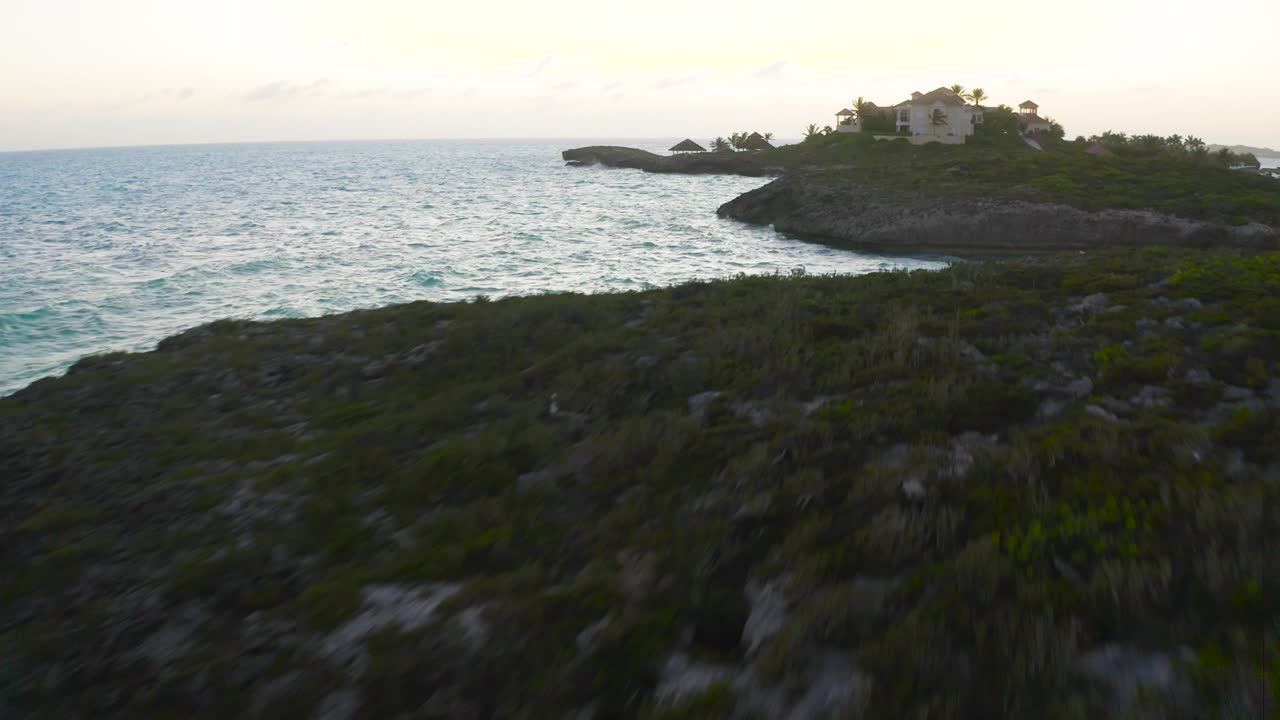 hermosa playa con olas salpicando rocas al atardecer en las islas turcas y caicos