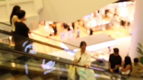 people using escalators in a bustling mall