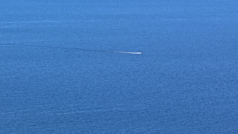 aerial view of a speedboat cutting across the calm blue waters of the baltic sea near the coast of latvia