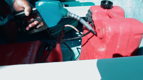 hombre llenando el tanque de combustible de un barco a motor antes del viaje