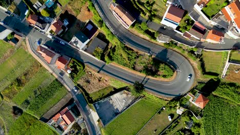 Vehículos-Circulando-Por-Carreteras-Curvas-A-Través-De-Casas-Y-Campos