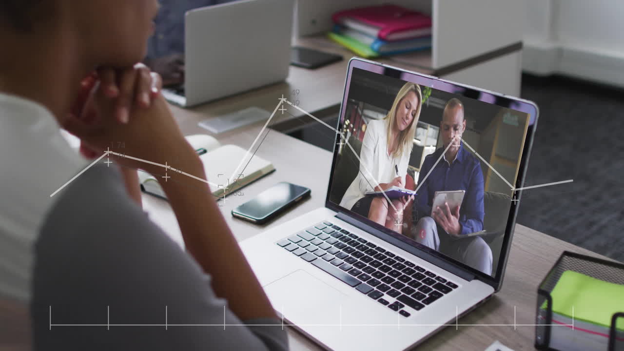 Laptop showing animation of data analysis graphics during business meeting call