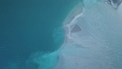 drone flying above partially frozen lake surface