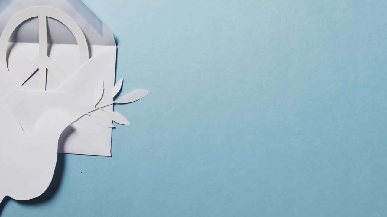 primer plano de paloma blanca con hoja, signo de paz blanco, sobre y espacio de copia sobre fondo azul