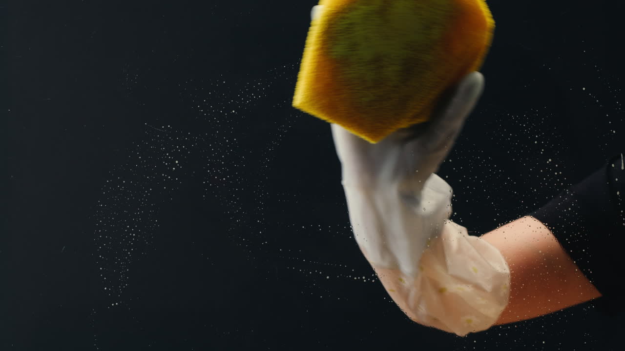 Hand in Glove Wiping Soap Suds on Glass Surface with Sponge