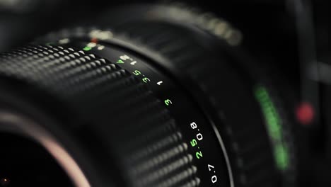 close-up focus pull on a classic vintage zoom lens, showcasing engraved markings and smooth mechanics