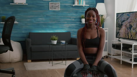 Portrait-of-athetic-woman-looking-into-camera-while-sitting-on-yoga-ball