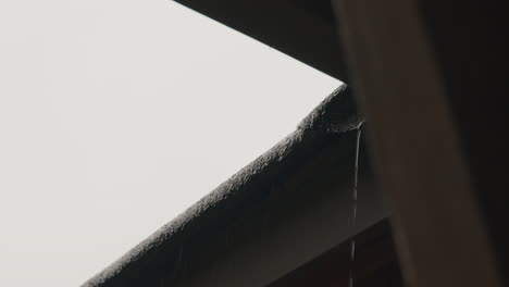 water falling down a roof during a rainstrom