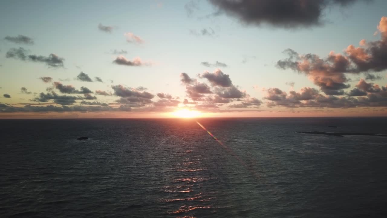 무인 항공기는 하와이 오아후 섬의 북쪽 해안 해안에서 매우 다채로운 하와이 일출을 향해 매우 높이 날아갑니다.