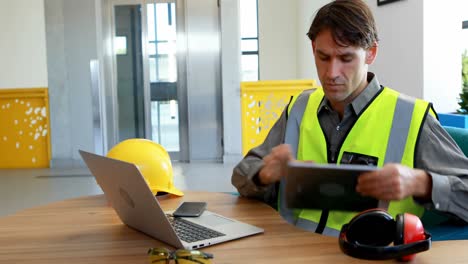 male worker using laptop and digital tablet at desk 4k