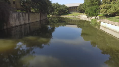 aerial of san antonio commercial area by downtown river walk in the morning with some pedestrians walking in the background