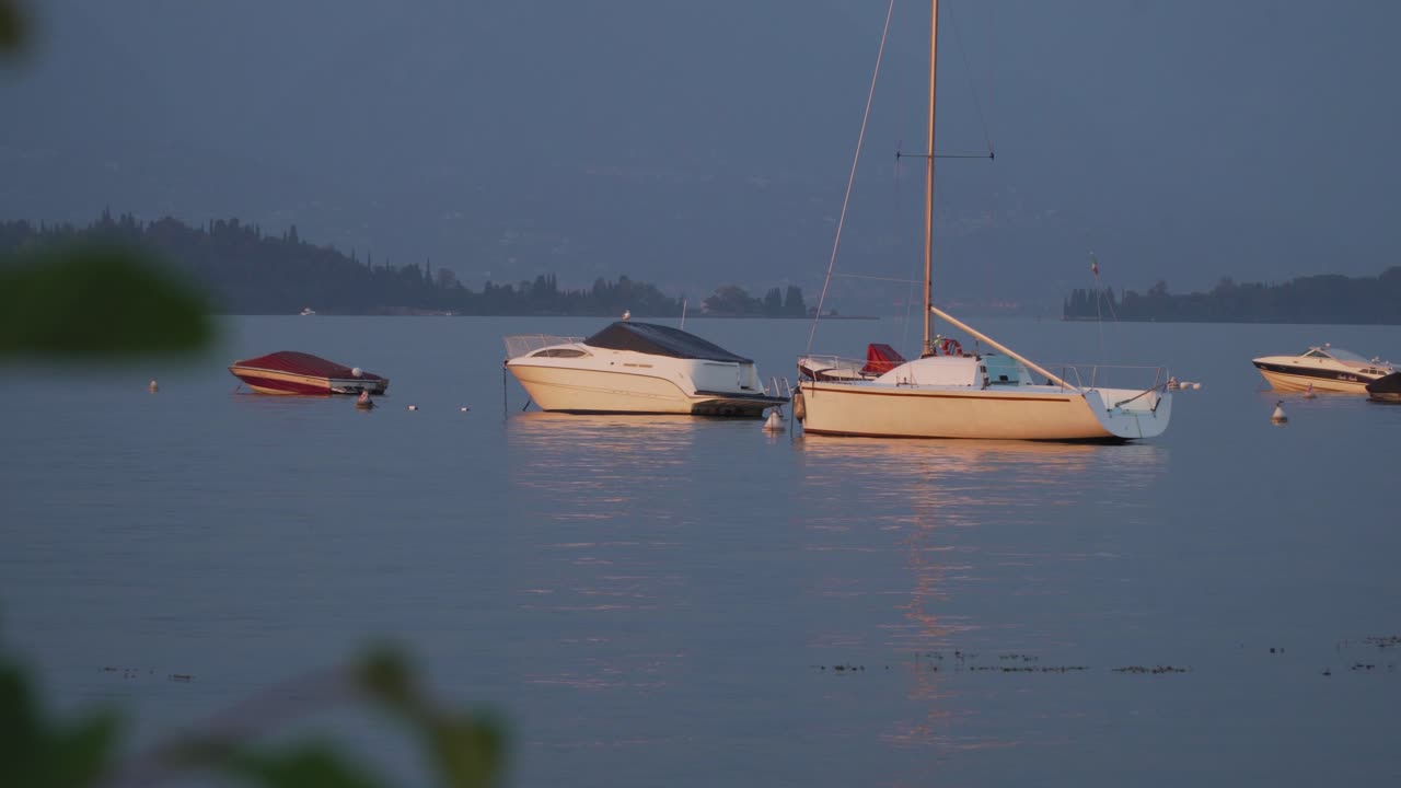 primera oscuridad en el deslumbrante hermoso lago de garda con diferentes barcos en primer plano