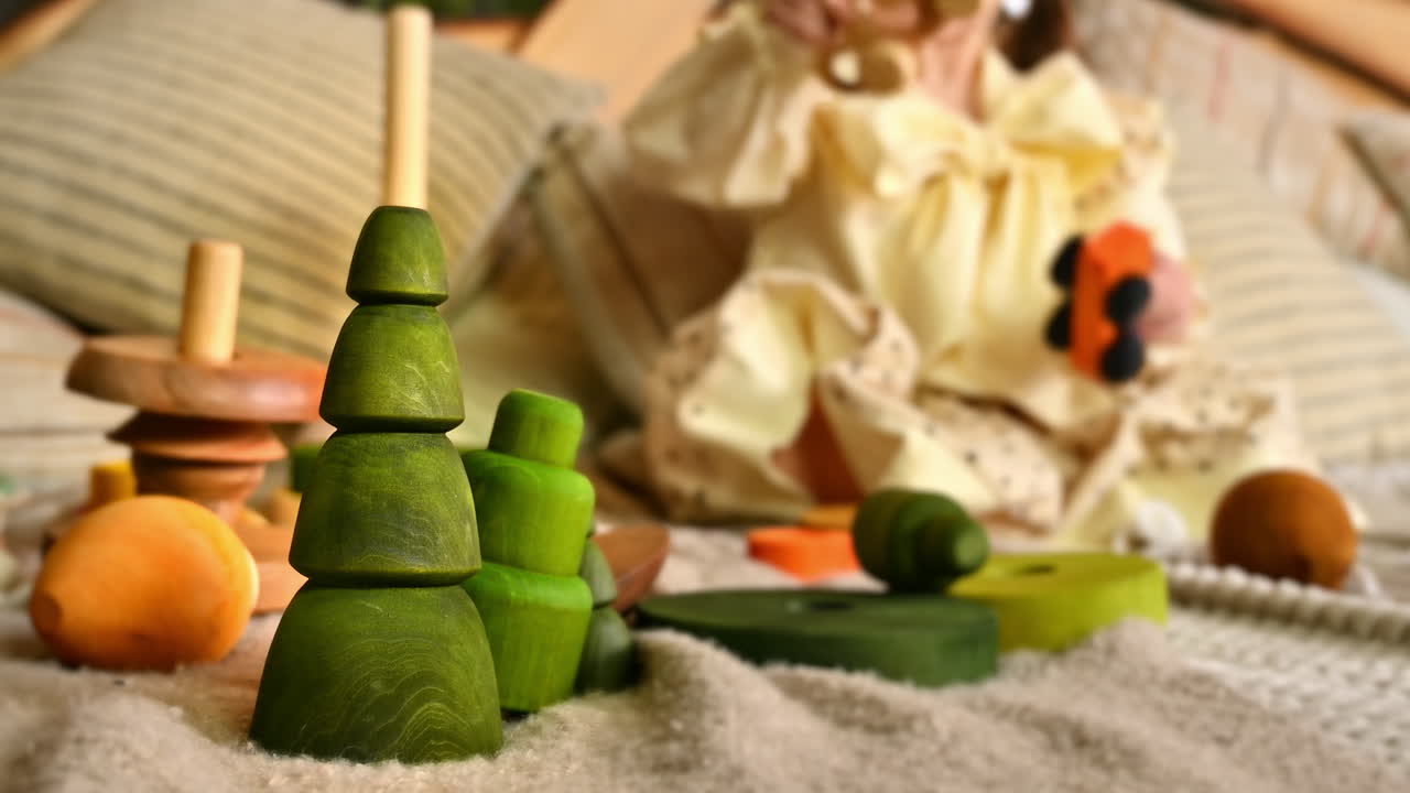 Little girl playing with several wooden toys in background. Green fir toy in foreground. Ecological and sustainability concept