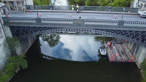 reveal aerial of an old iron bridge undergoing maintenance